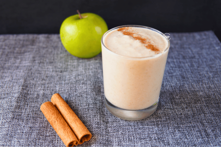 Smoothie u staklenoj čaši, jabuka i cimet, Smoothie in a glass with apple and cinammon sticks on the table