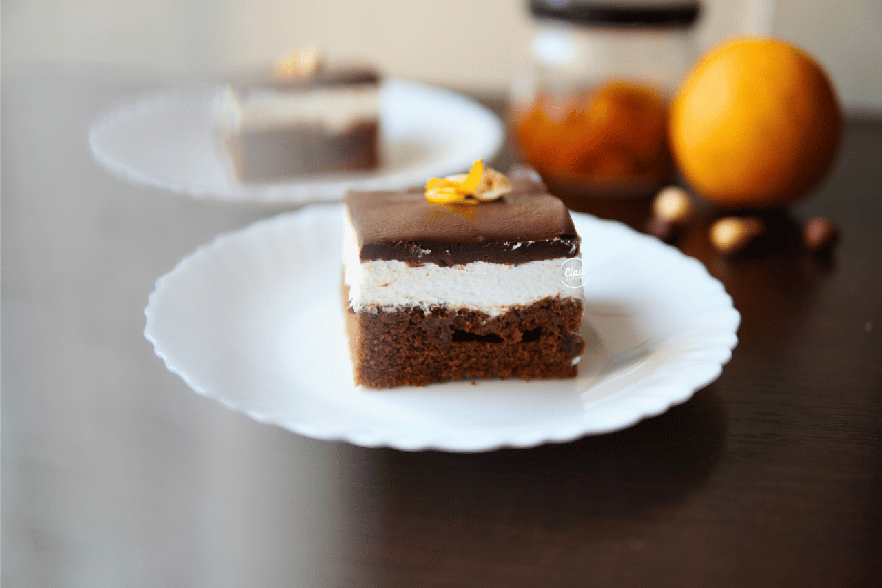 Maskarpone kolač na belom tanjiru i narandža, Mascarpone cake on a white plate and orange