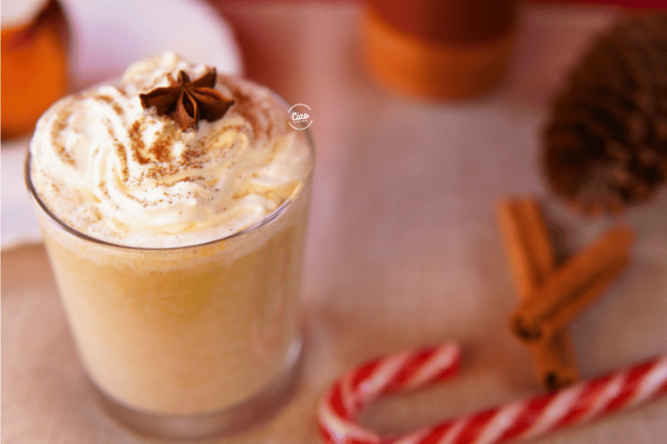 Napitak od bundeve u staklenoj čaši i štapići cimeta, Pumpkin spice chai in a glass with cinammon sticks on the table