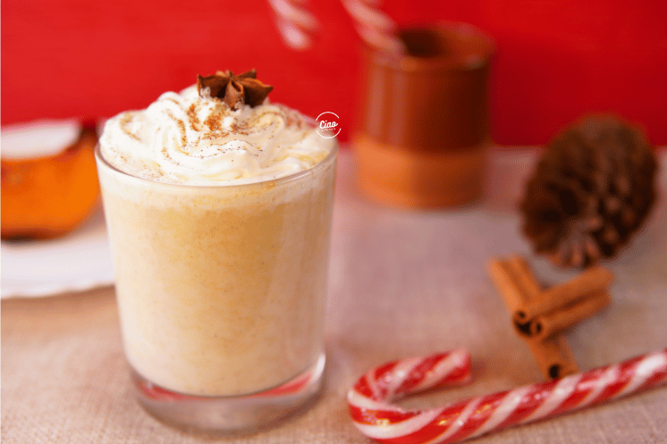 Napitak od bundeve u staklenoj čaši i štapići cimeta, Pumpkin spice chai in a glass with cinammon sticks on the table