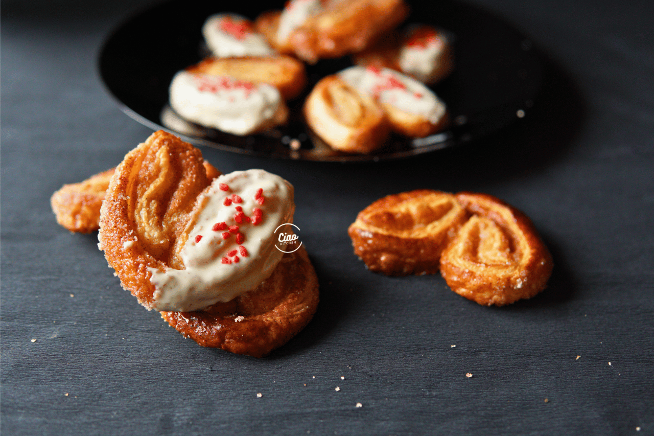 Palmiers kolači polovinom umočeni u belu čokoladu sa crvenim šećerom, Palmiers half dipped in white chocolate with red sugar