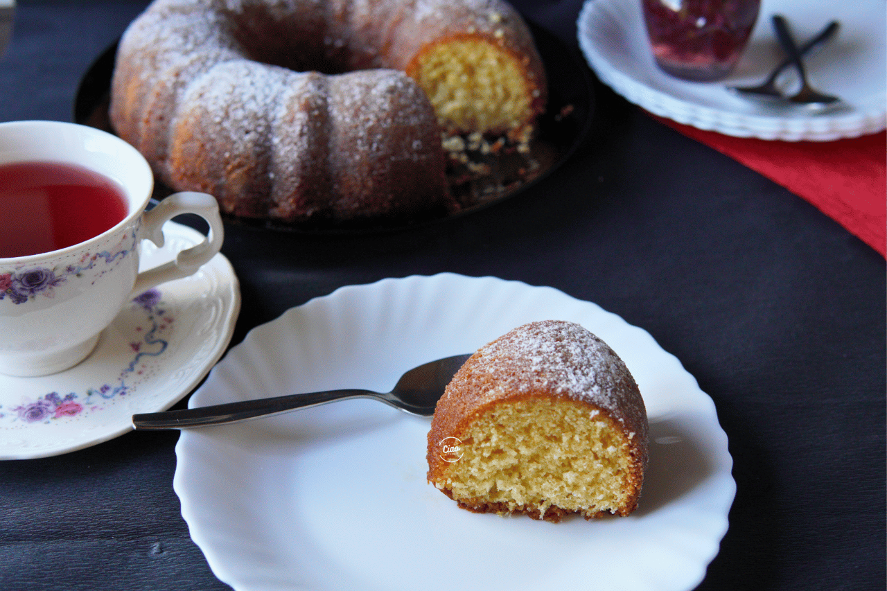 Jedno parče kuglofa na belom tanjiru i šoljica čaja, One peice of Kuglof on white plate with cup of tea